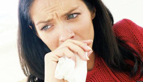 Женщина закрывает рот носовым платком
